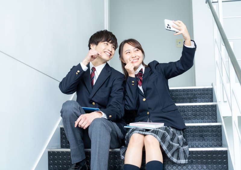 SNSにアップロードするために自撮りをする高校生
