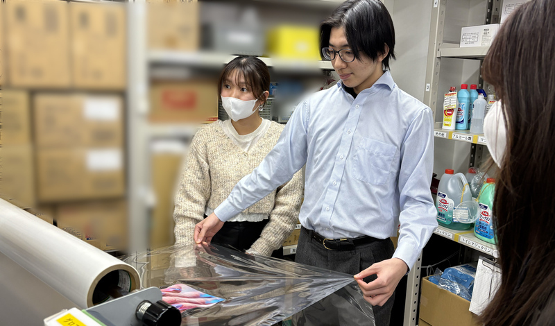 高校生が職場見学でラミネート体験をしている様子