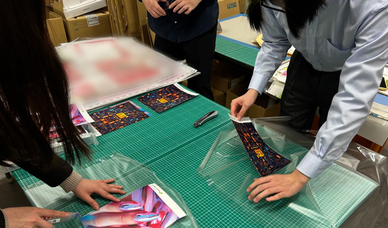 高校生が職場見学でラミネート体験をしている様子②