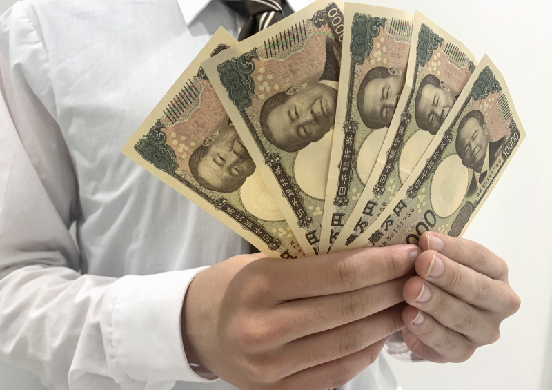 就職して得たお金を手にするをする高卒社員